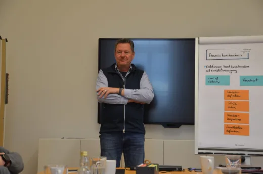 Martin Lange vor Bildschirm und Flipchart mit Karten