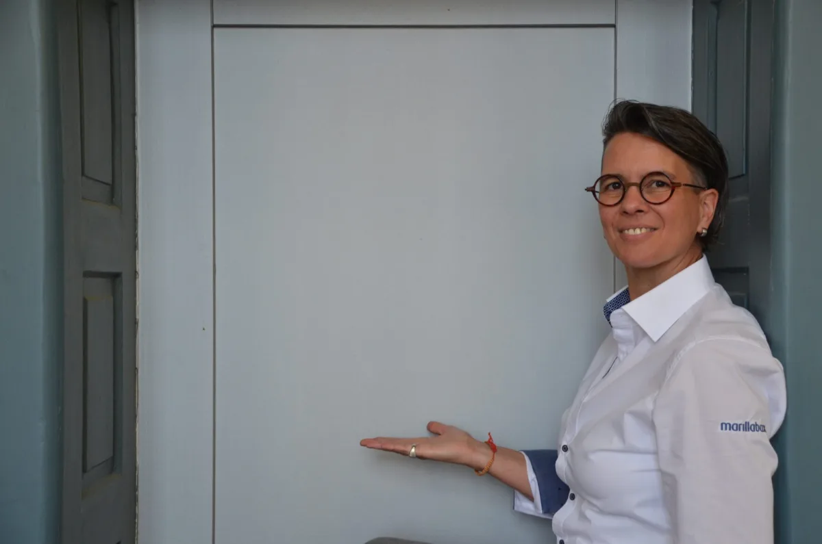Marilla Bax lädt mit einer Handbewegung zur Tür herein